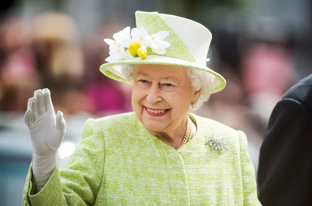  Яркий костюм, шляпка в тон и рука в перчатке – такой мы помним королеву Елизавету II.
