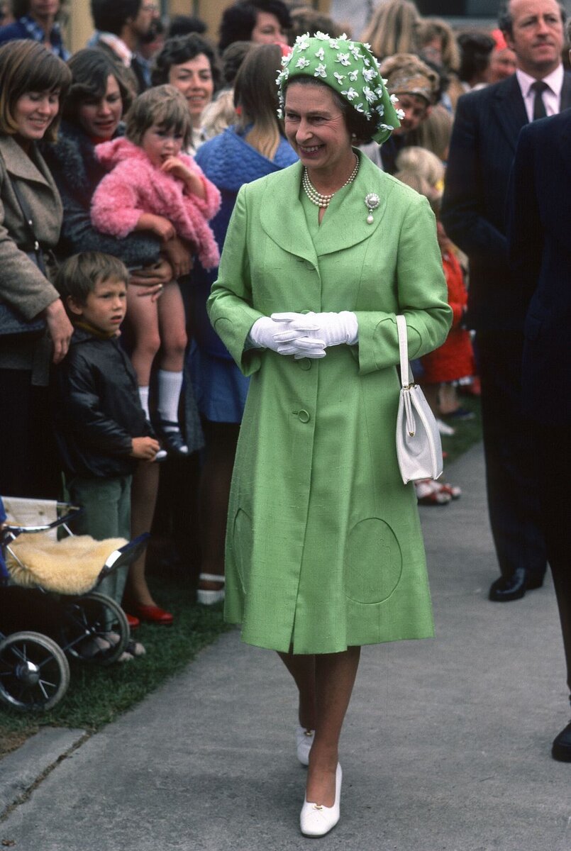  Яркий костюм, шляпка в тон и рука в перчатке – такой мы помним королеву Елизавету II.-17