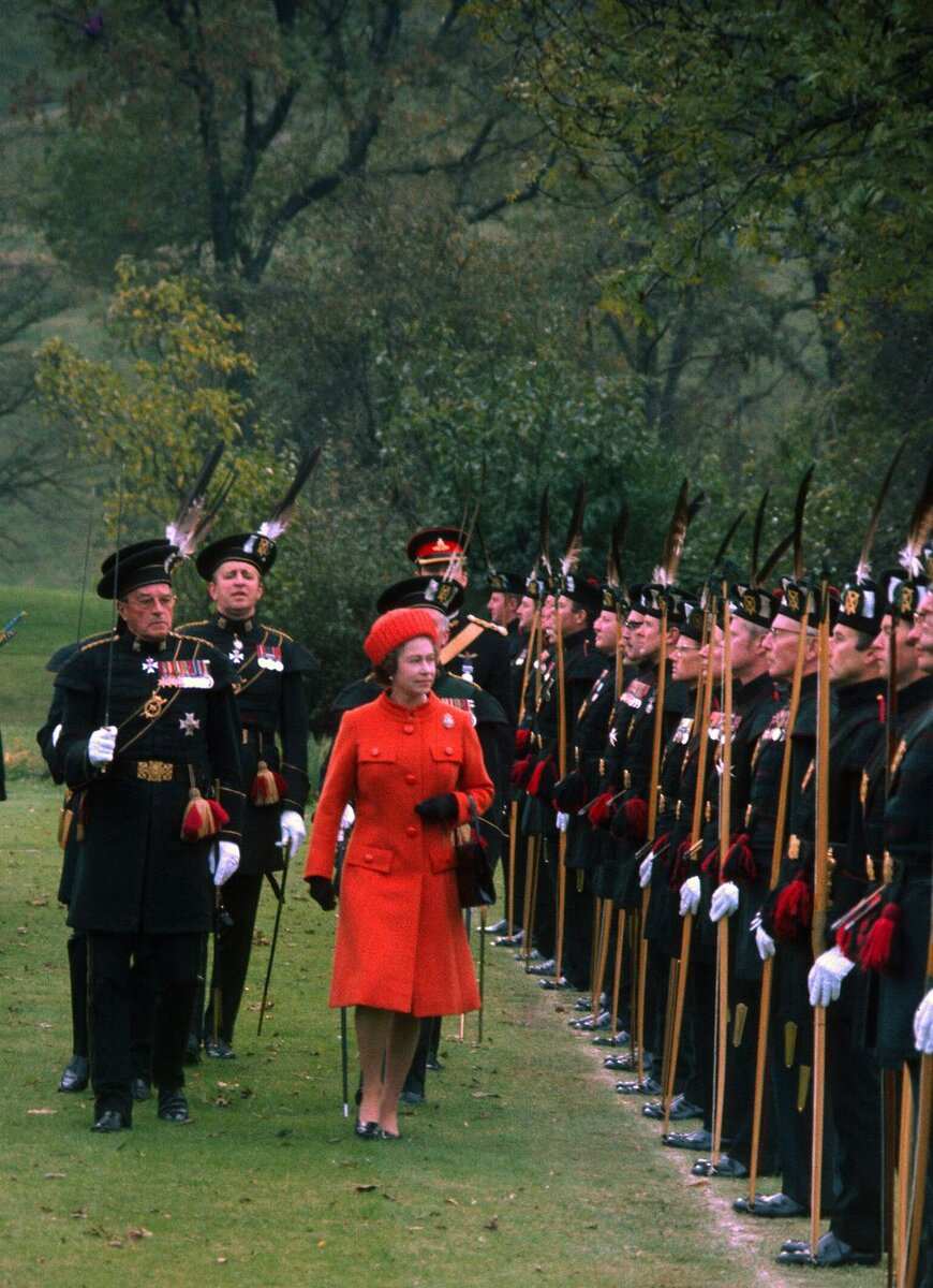  Яркий костюм, шляпка в тон и рука в перчатке – такой мы помним королеву Елизавету II.-21