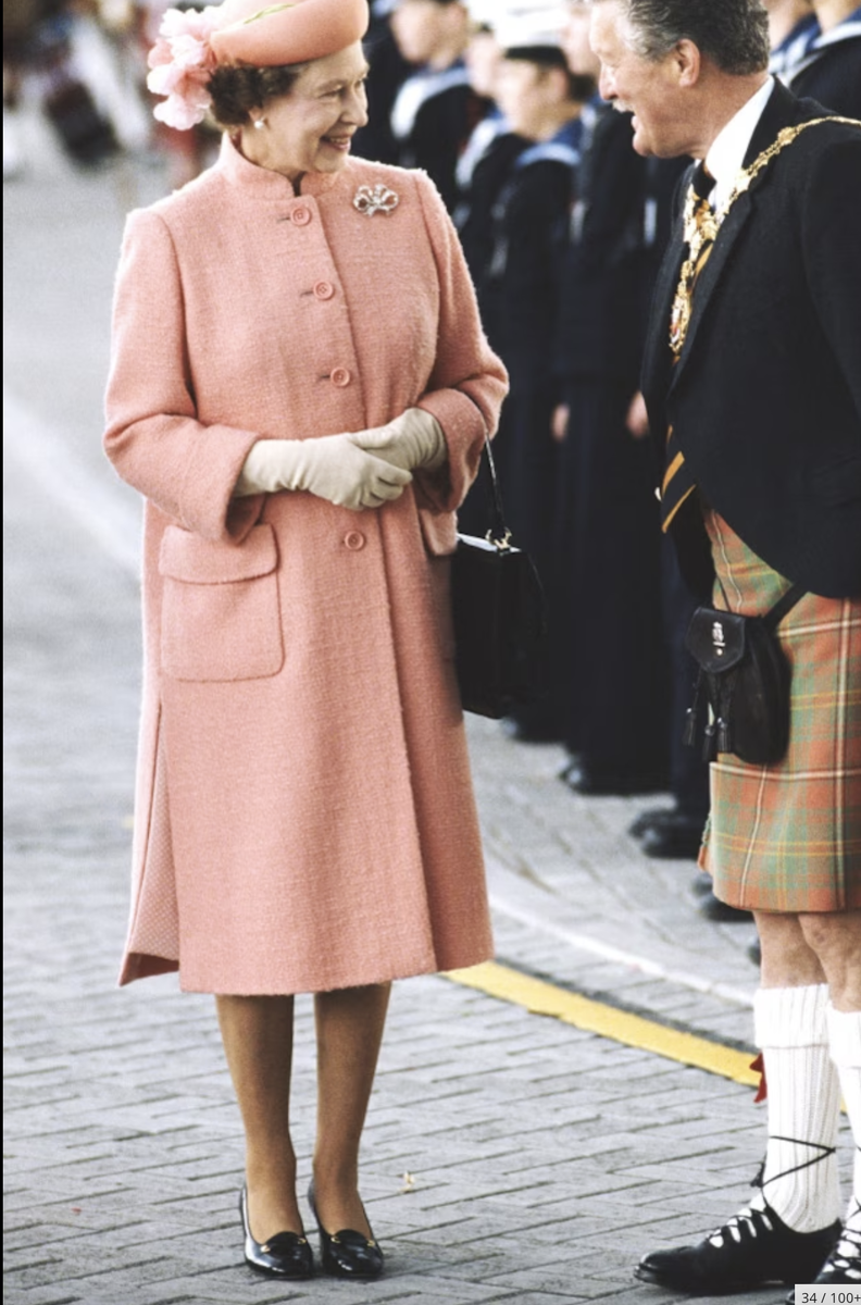  Яркий костюм, шляпка в тон и рука в перчатке – такой мы помним королеву Елизавету II.-31