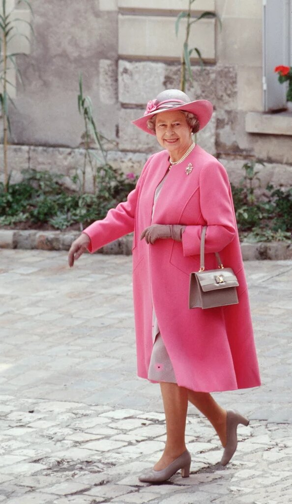  Яркий костюм, шляпка в тон и рука в перчатке – такой мы помним королеву Елизавету II.-33