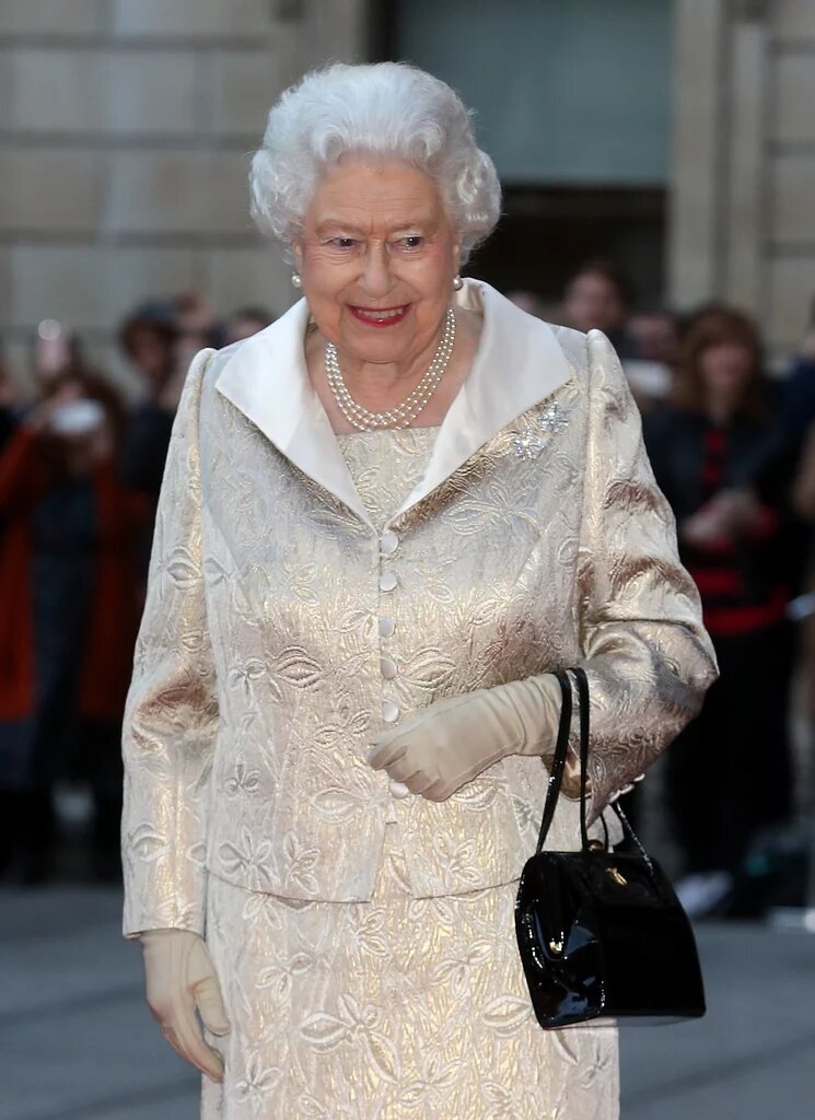 Яркий костюм, шляпка в тон и рука в перчатке – такой мы помним королеву Елизавету II.-36