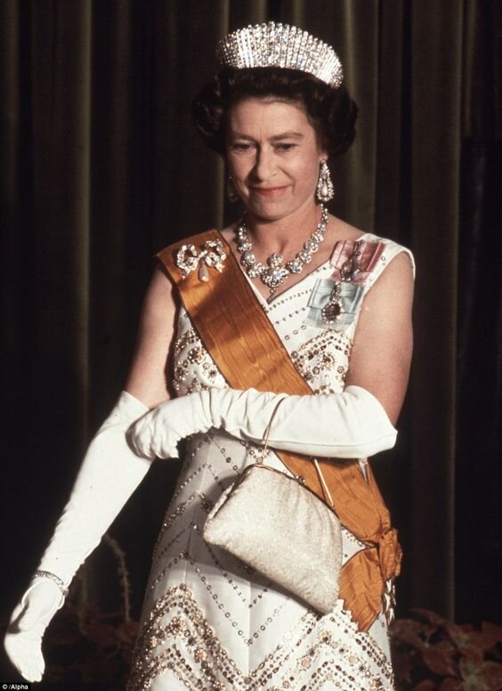  Яркий костюм, шляпка в тон и рука в перчатке – такой мы помним королеву Елизавету II.-39