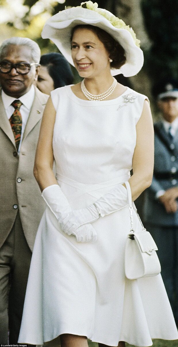  Яркий костюм, шляпка в тон и рука в перчатке – такой мы помним королеву Елизавету II.-47