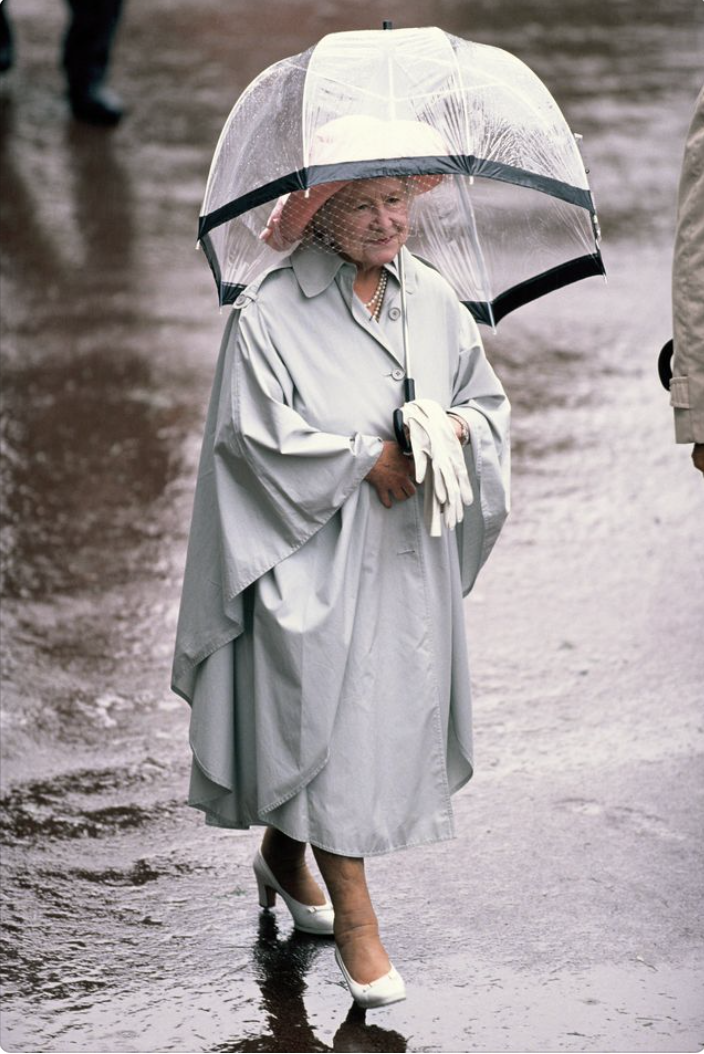  Королева Елизавета II и ее аксессуары. Какие ассоциации? Первое – черные сумочки, второе – белые перчатки, третье – прозрачные зонтики с цветной полосой.-4