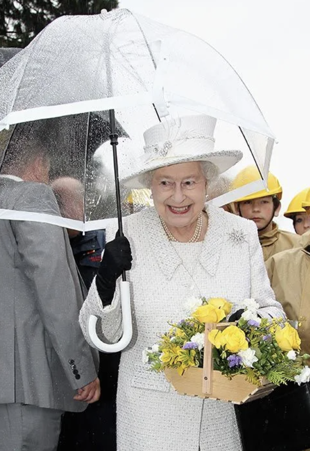  Королева Елизавета II и ее аксессуары. Какие ассоциации? Первое – черные сумочки, второе – белые перчатки, третье – прозрачные зонтики с цветной полосой.-11