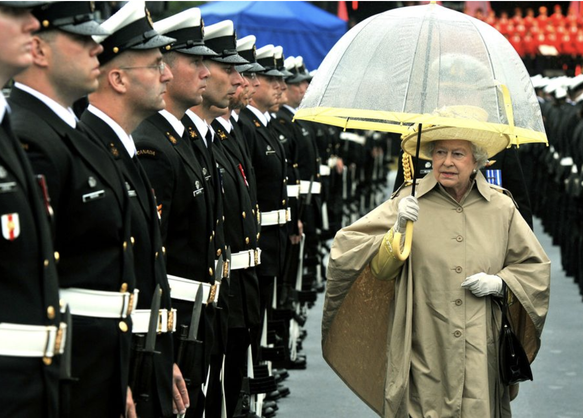  Королева Елизавета II и ее аксессуары. Какие ассоциации? Первое – черные сумочки, второе – белые перчатки, третье – прозрачные зонтики с цветной полосой.-14