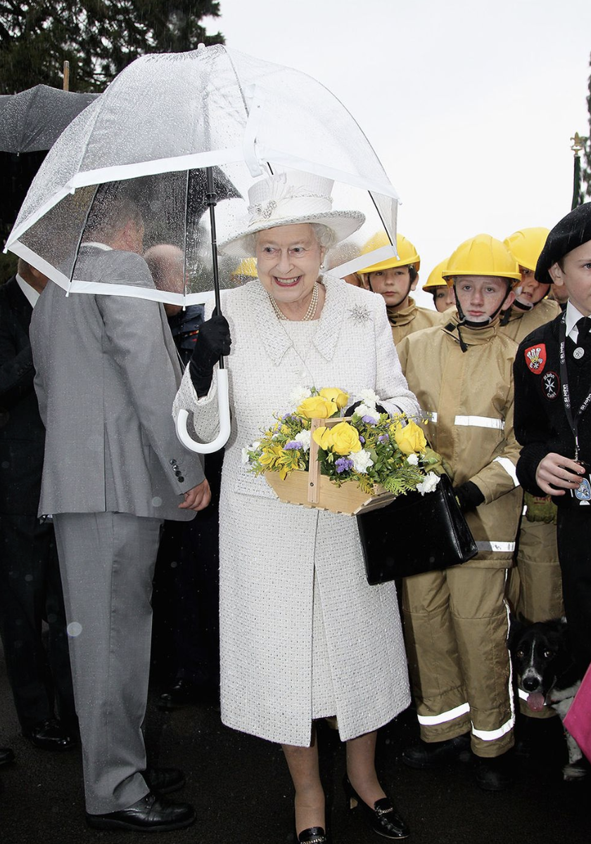  Королева Елизавета II и ее аксессуары. Какие ассоциации? Первое – черные сумочки, второе – белые перчатки, третье – прозрачные зонтики с цветной полосой.-16
