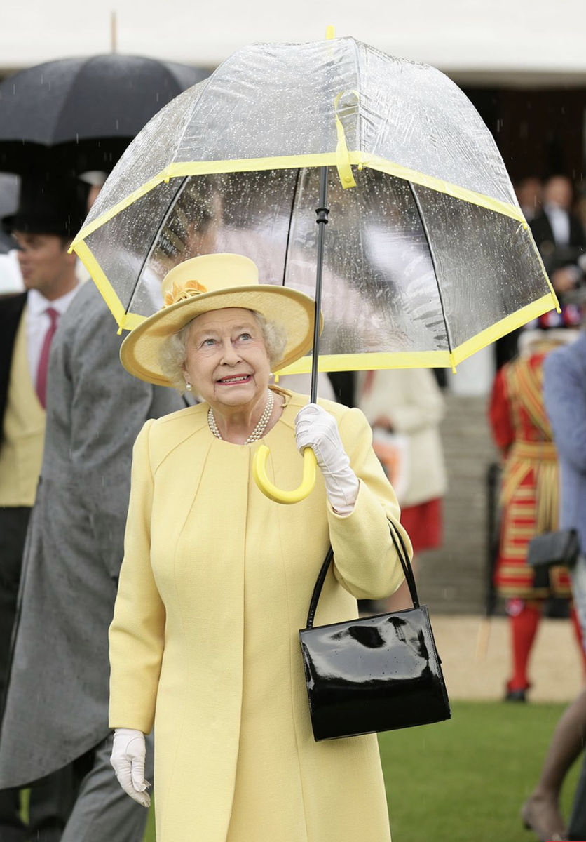  Королева Елизавета II и ее аксессуары. Какие ассоциации? Первое – черные сумочки, второе – белые перчатки, третье – прозрачные зонтики с цветной полосой.-21