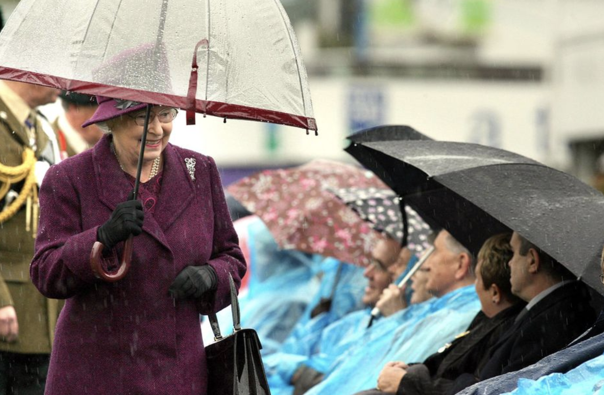  Королева Елизавета II и ее аксессуары. Какие ассоциации? Первое – черные сумочки, второе – белые перчатки, третье – прозрачные зонтики с цветной полосой.-24