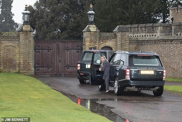 Pictured: The Queen arriving back at Windsor Castle from Buckingham Palace to find the gate locked, as a female bodyguard steps out of one of the Range Rovers