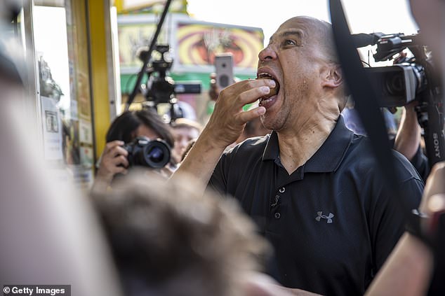 Кандидат в президенты от Демократической партии сенатор Кори Букер ест сэндвич с арахисовым маслом и желе во фритюре на ярмарке штата Айова 10 августа 2019 года